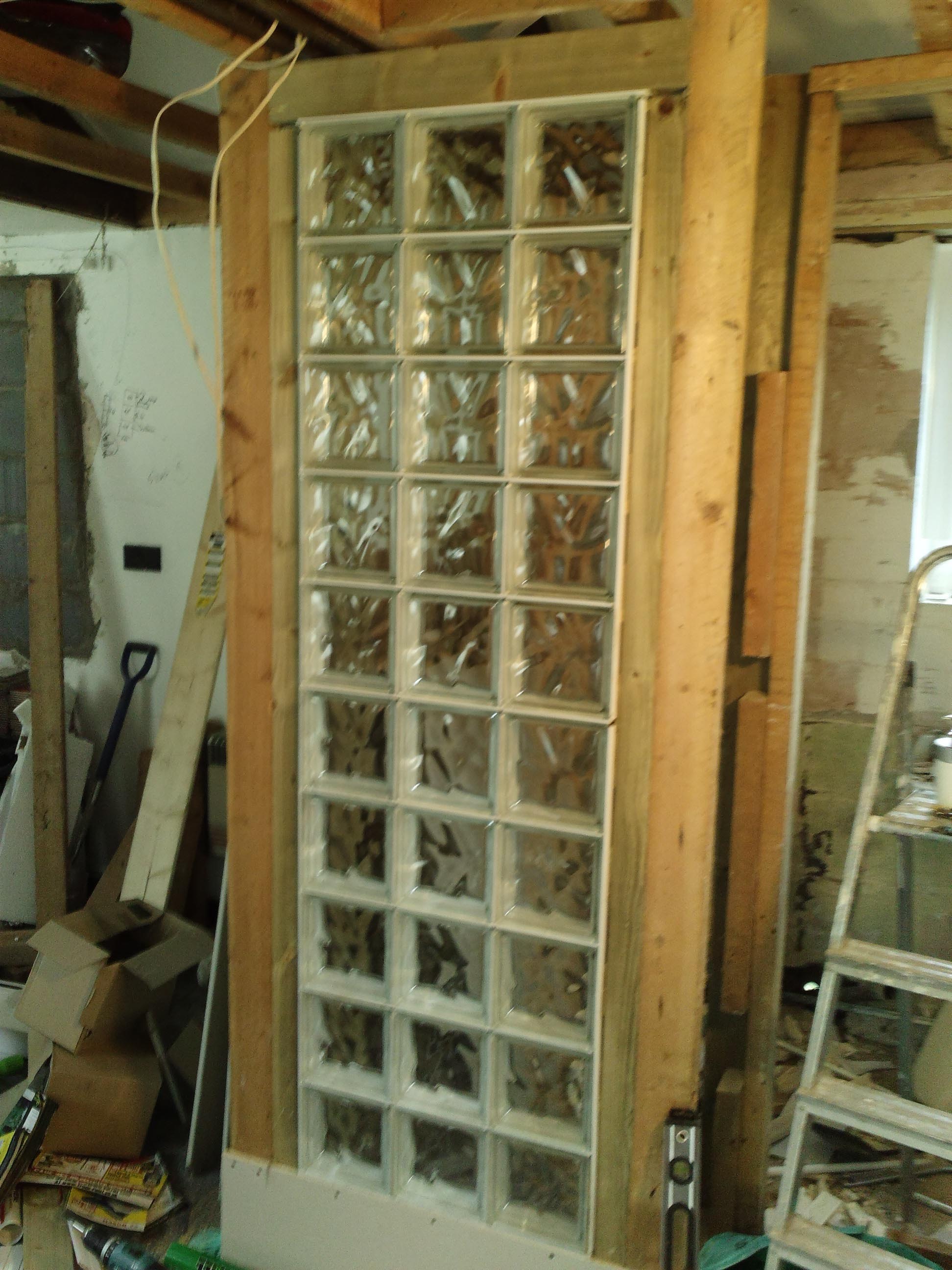 Glass blocks were fitted in a bespoke wooden stud work so they would be flush with the tiles in the shower, and flush with the plasterboard in the living area. 