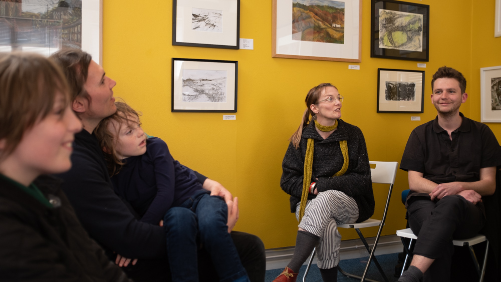 Anna Jones describing some of her work as family members look on.