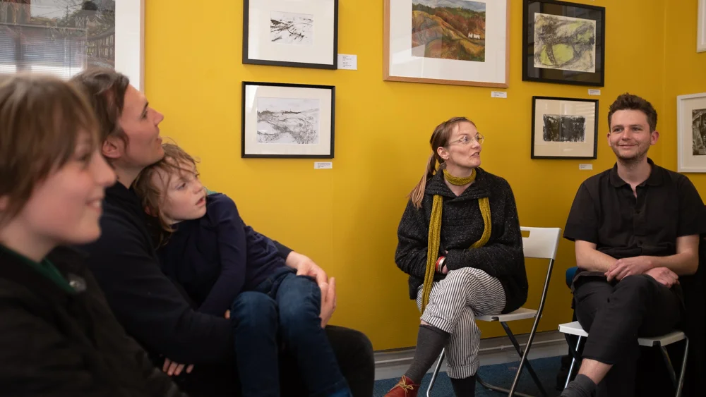 Anna Jones describing some of her work as family members look on.