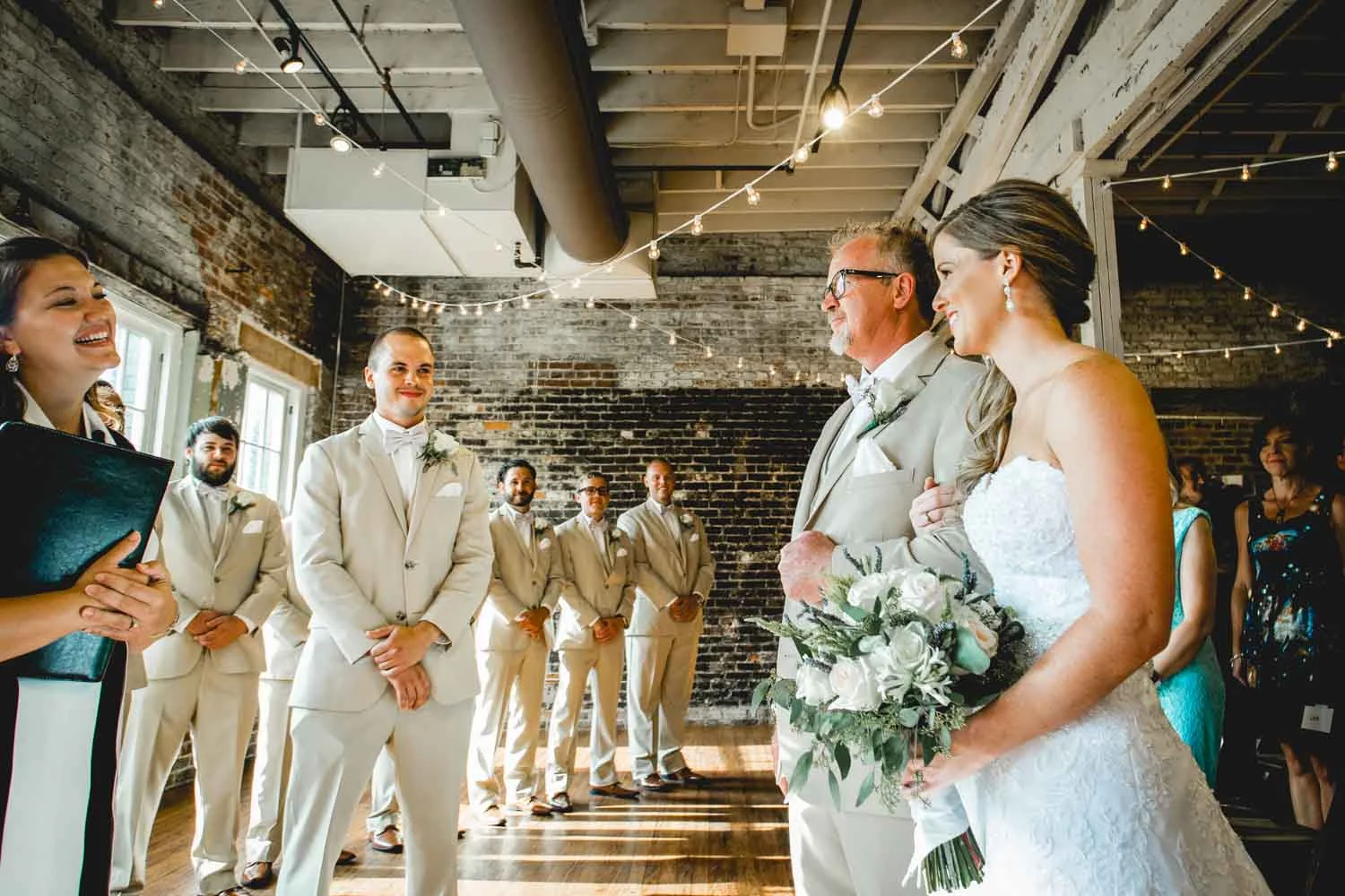 Daniel K. Photography captures a photograph of a groom as he waits for his bride as she walks down the aisle at The Stockroom 230 in Raleigh, NC.