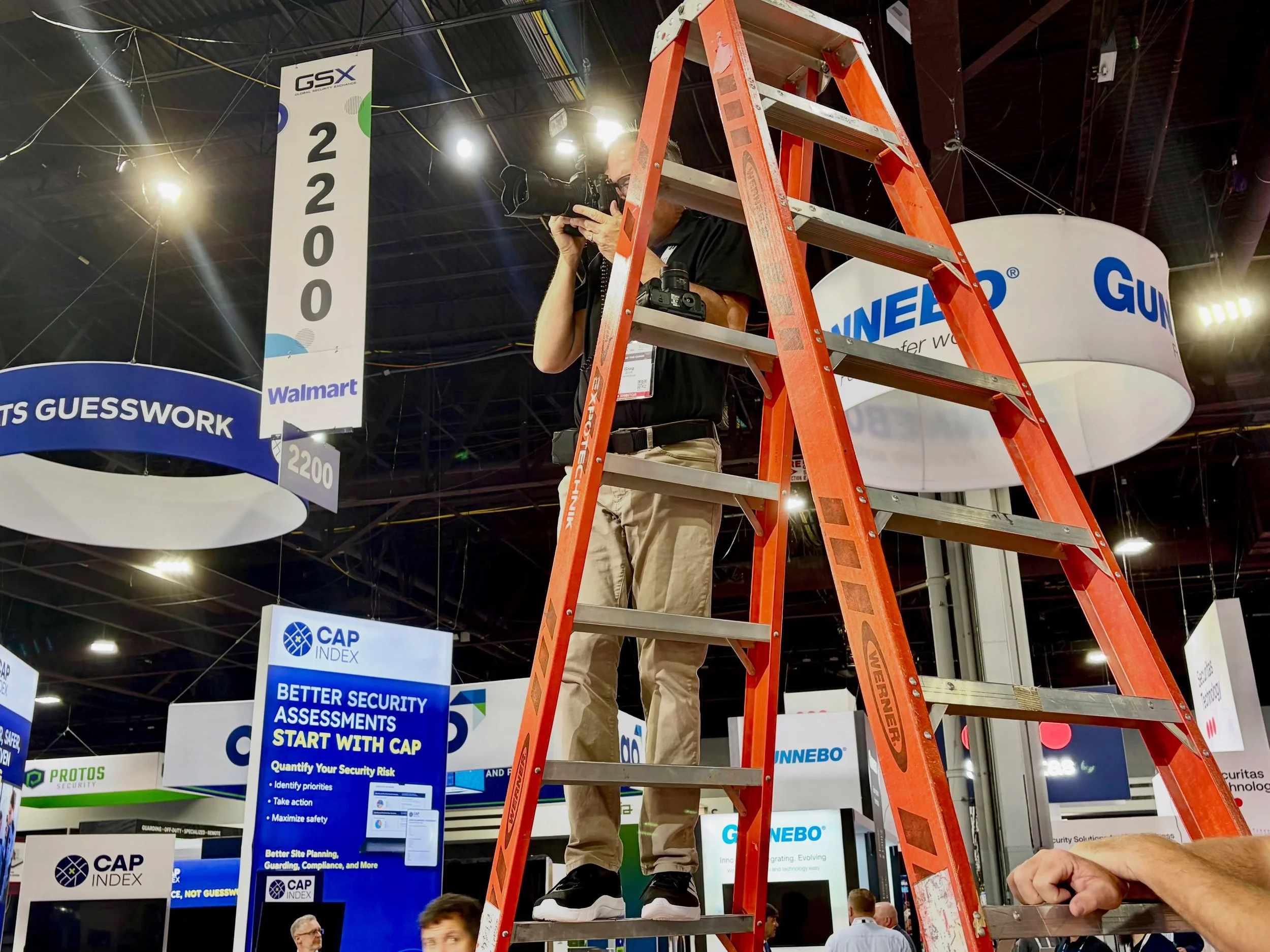 Officer Greg perched atop the ladder for overhead shots in the expo hall at #GSX2026! This conference is massive, by the way!
