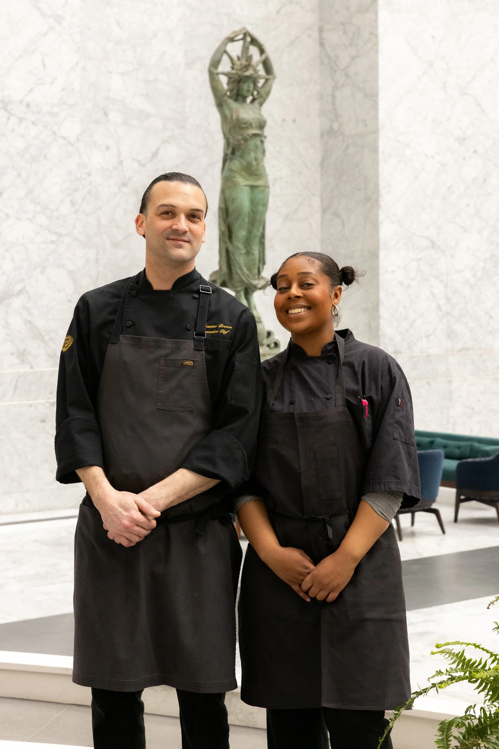 Two standing in front of statue at Sprouts Chef Training