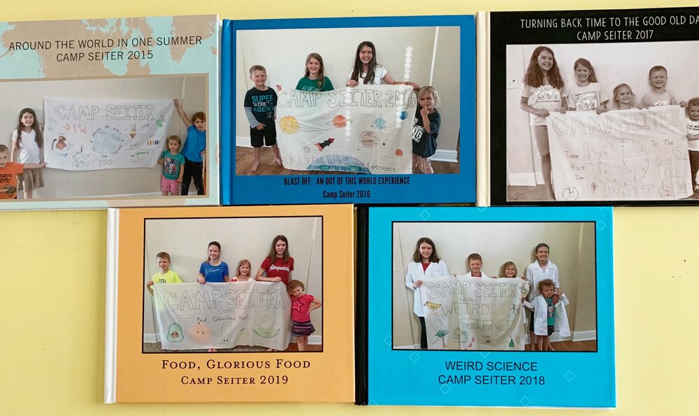 The cover of each photo book features the annual Camp Seiter theme reveal banner!