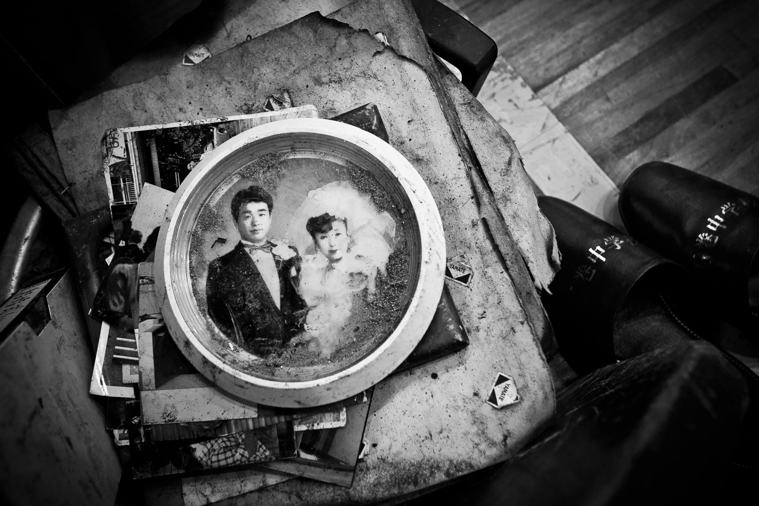 Ishinomaki, Japan, 2011. In the corner of yet another evacuation center, in a pile of orphaned photos and notes found in the mud and debris, a newlywed couple stares into a future turned upside down. Their frame and glass still covered in dry mud from a disaster hitting like a lightning from the sky.