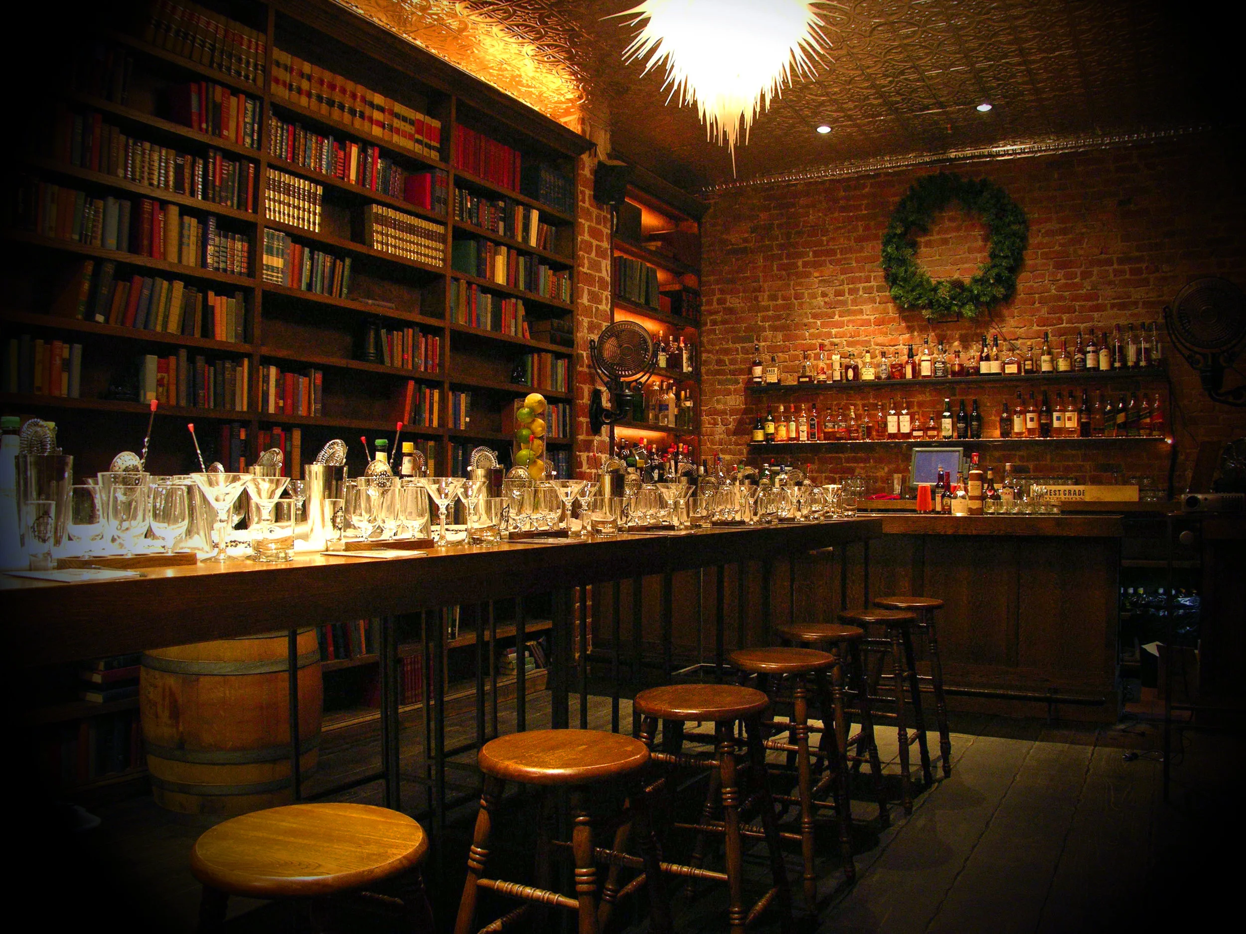 Bourbon & Branch in San Francisco, bar counter with lots of glasses and different books. bar stools, drinks of shelf