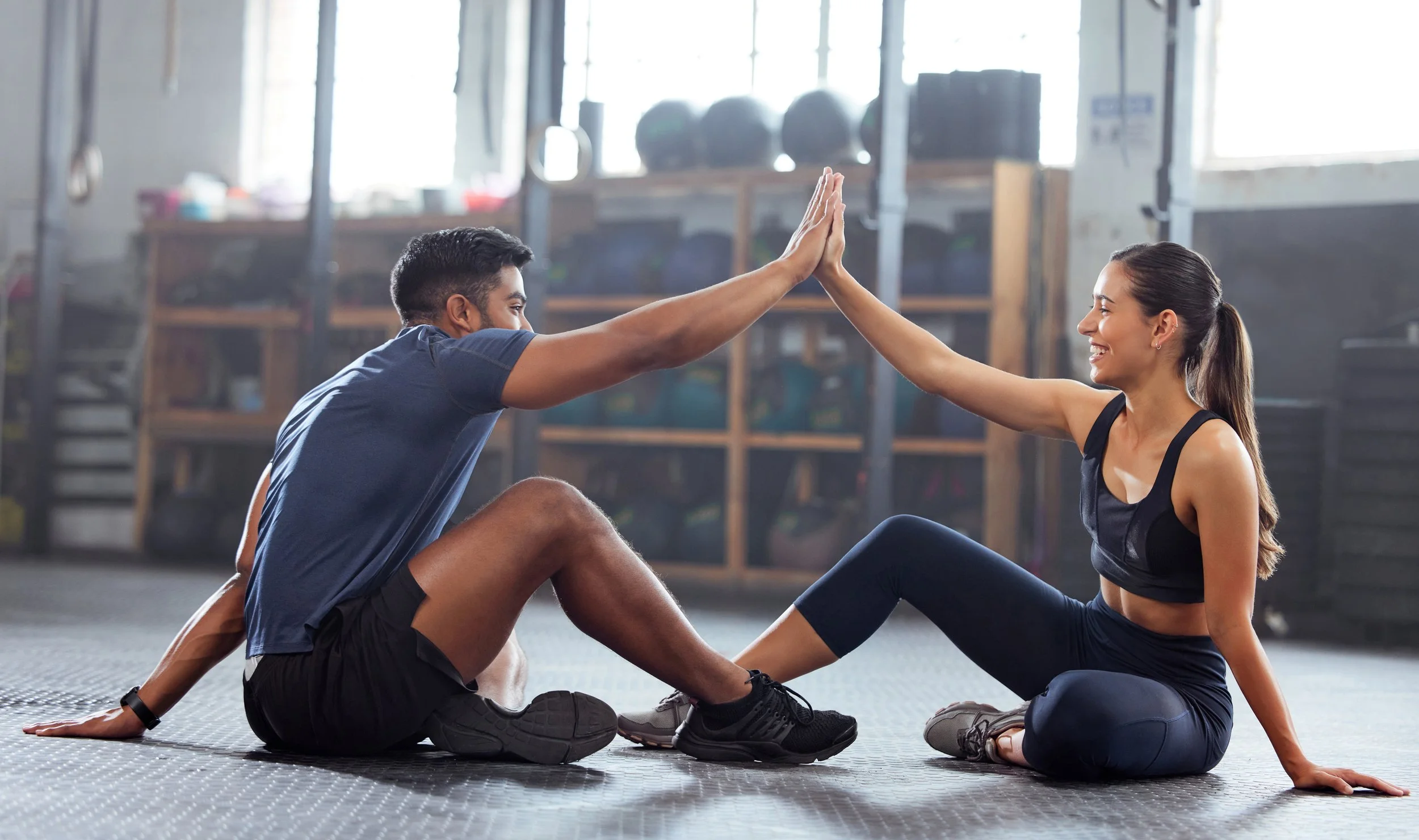  Female high five with her personal trainer or coach in the gym. Active fit woman training fitness, . 