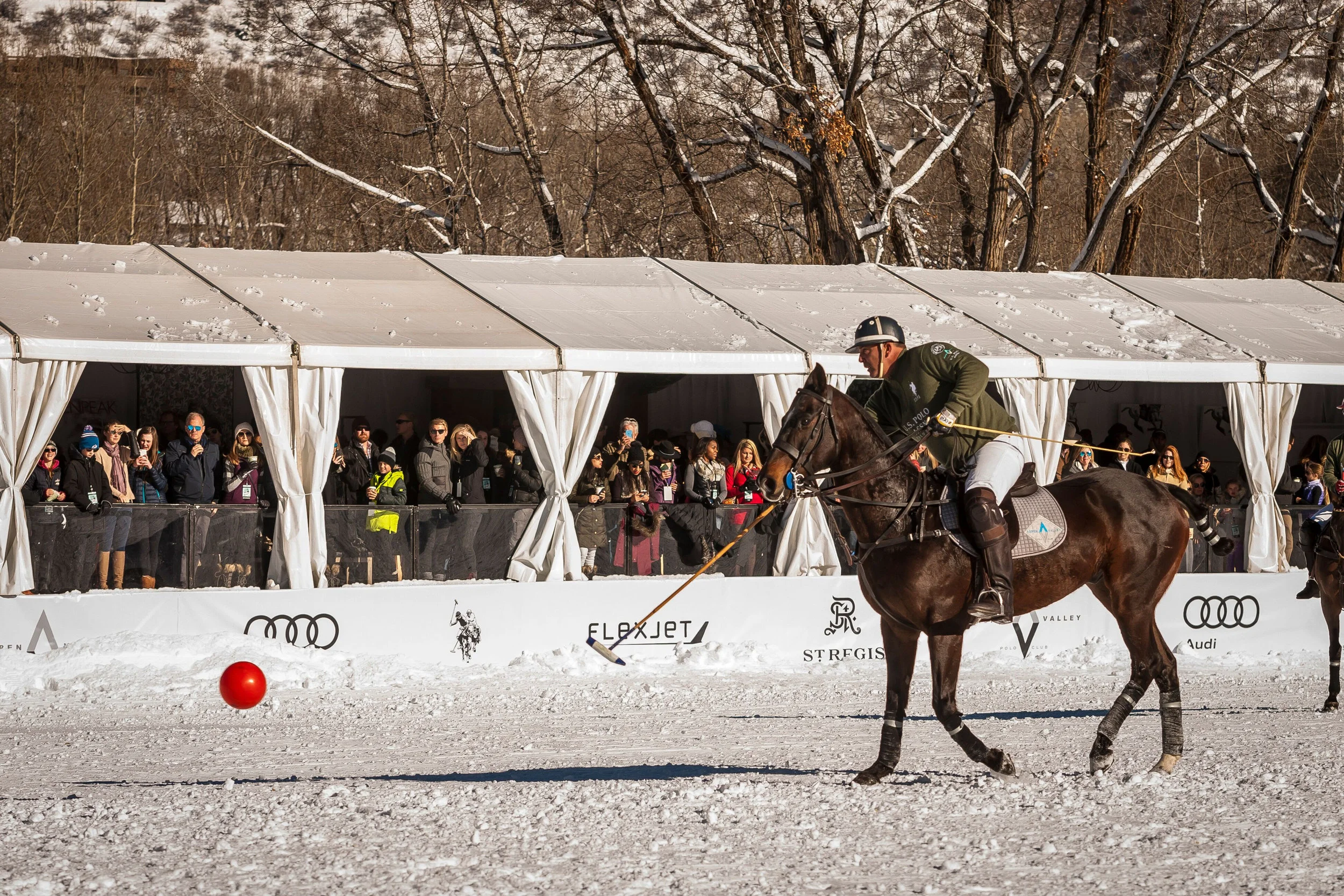 A soldout VIP tent at Rio Grande Park watches snow polo action.