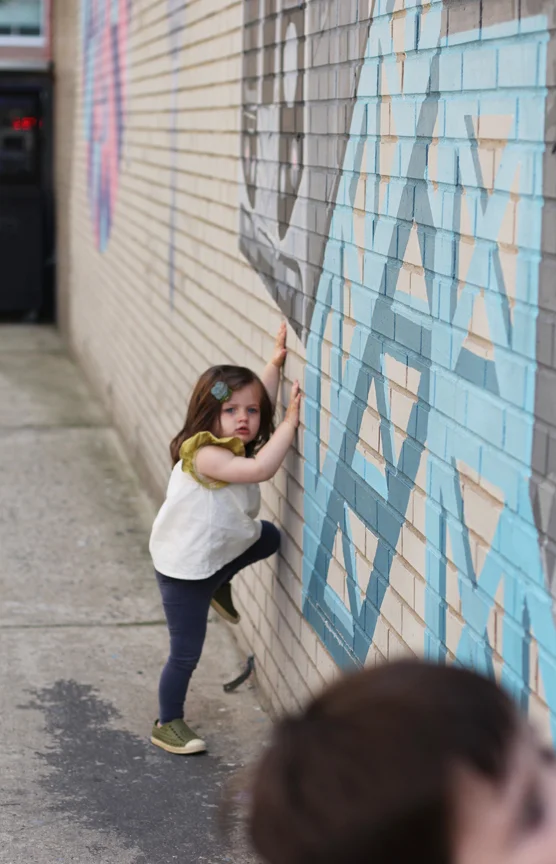 At a certain point, Alice decided she wanted to climb the wall. Every time she wants help, she makes this super fake exasperated exertion sound "uh uh," like she's trying but can't. She does this in lieu of actually trying. It's really funny. Especially when it's over something like trying to climb the exterior of a 60' prison wall. (Ok, technically it's not a prison, it's a jail . This mural is on the exterior of the Brooklyn House of Detention.)