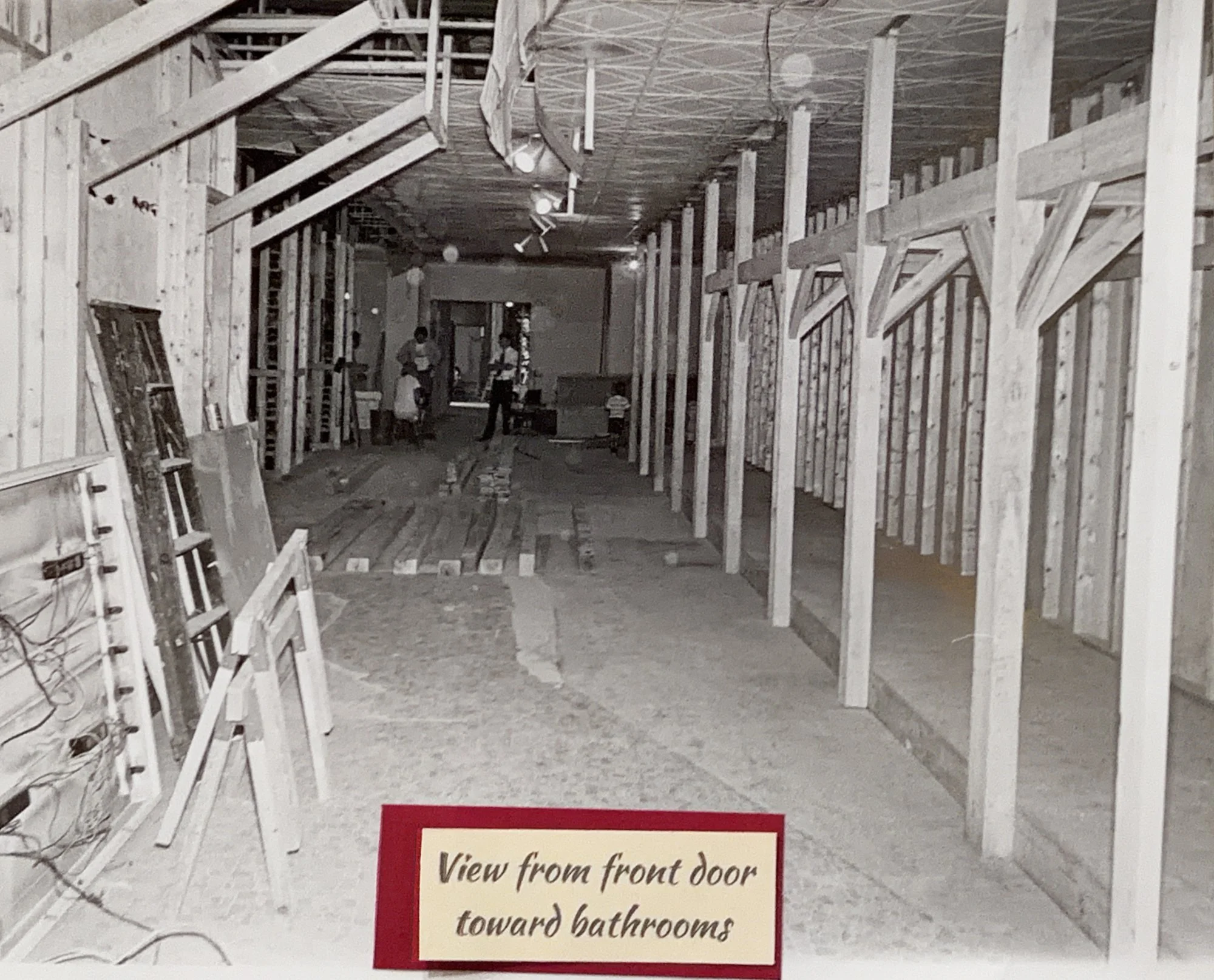 Wood framing going up inside the future Saloon, labeled 'View from front door toward bathrooms'