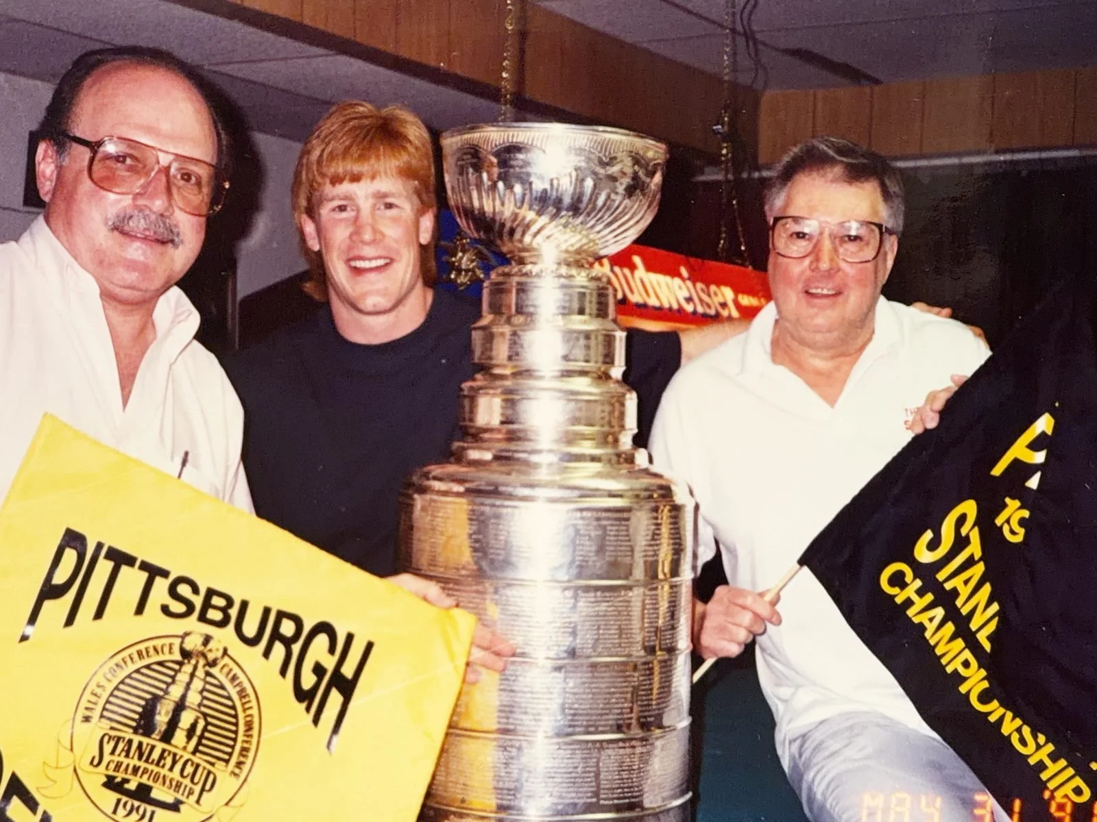 Penguin Troy Loney with two men, the Stanley Cup and 1991 Stanley Cup Championship pennants at The Saloon, May 31, 1991