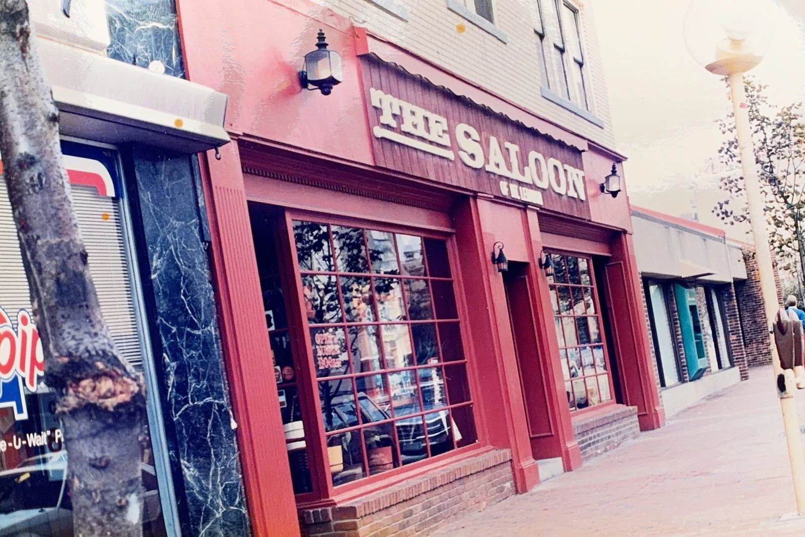 Close-up of The Saloon of Mt. Lebanon's red storefront with the 'The Saloon of Mt. Lebanon' sign, 1980s