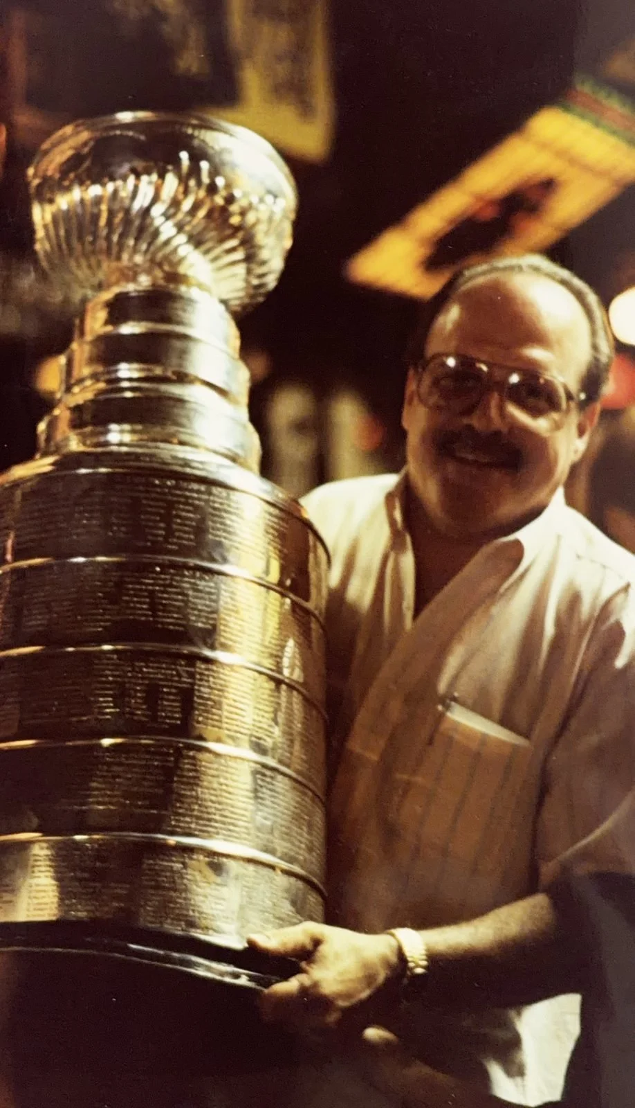 A man in glasses holds the Stanley Cup at The Saloon's bar, 1991