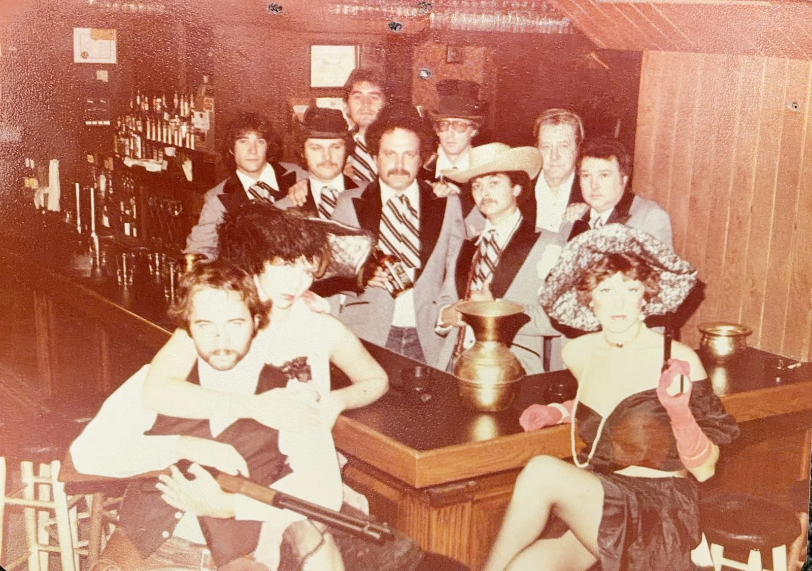 The Saloon's original staff in Old West costume at the bar, 1976