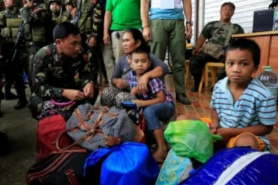 An Army officer talks to residents who were rescued as government troops retake Marawi from the Maute group. Photo by Romeo Ranoco, Reuters.
