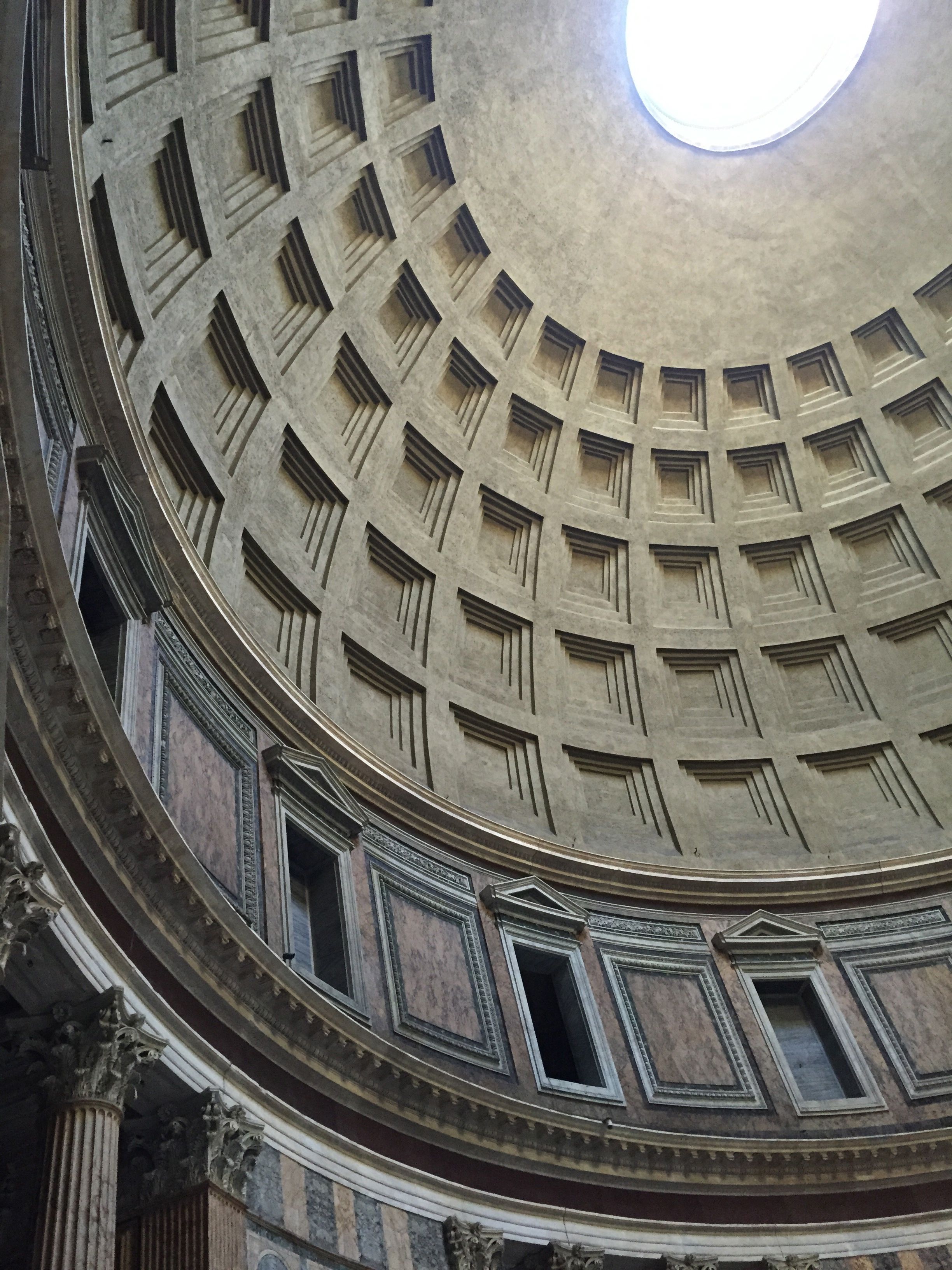 Inside the Pantheon in Rome looking up at the massive dome.