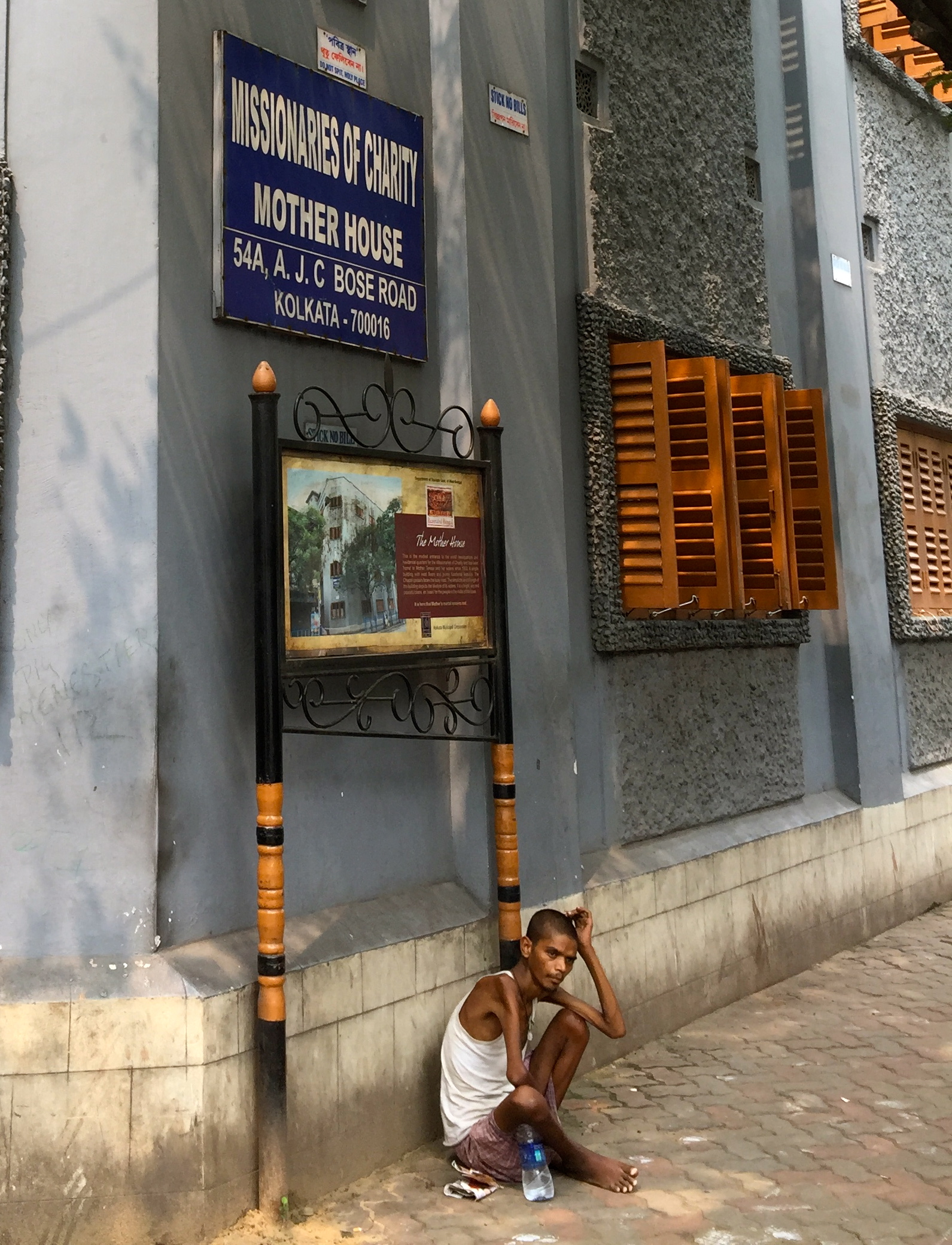 Malnourished young man sits at the corner of the home of Mother Teresa's Order of the Missionaries of Charity, hoping for a handout.
