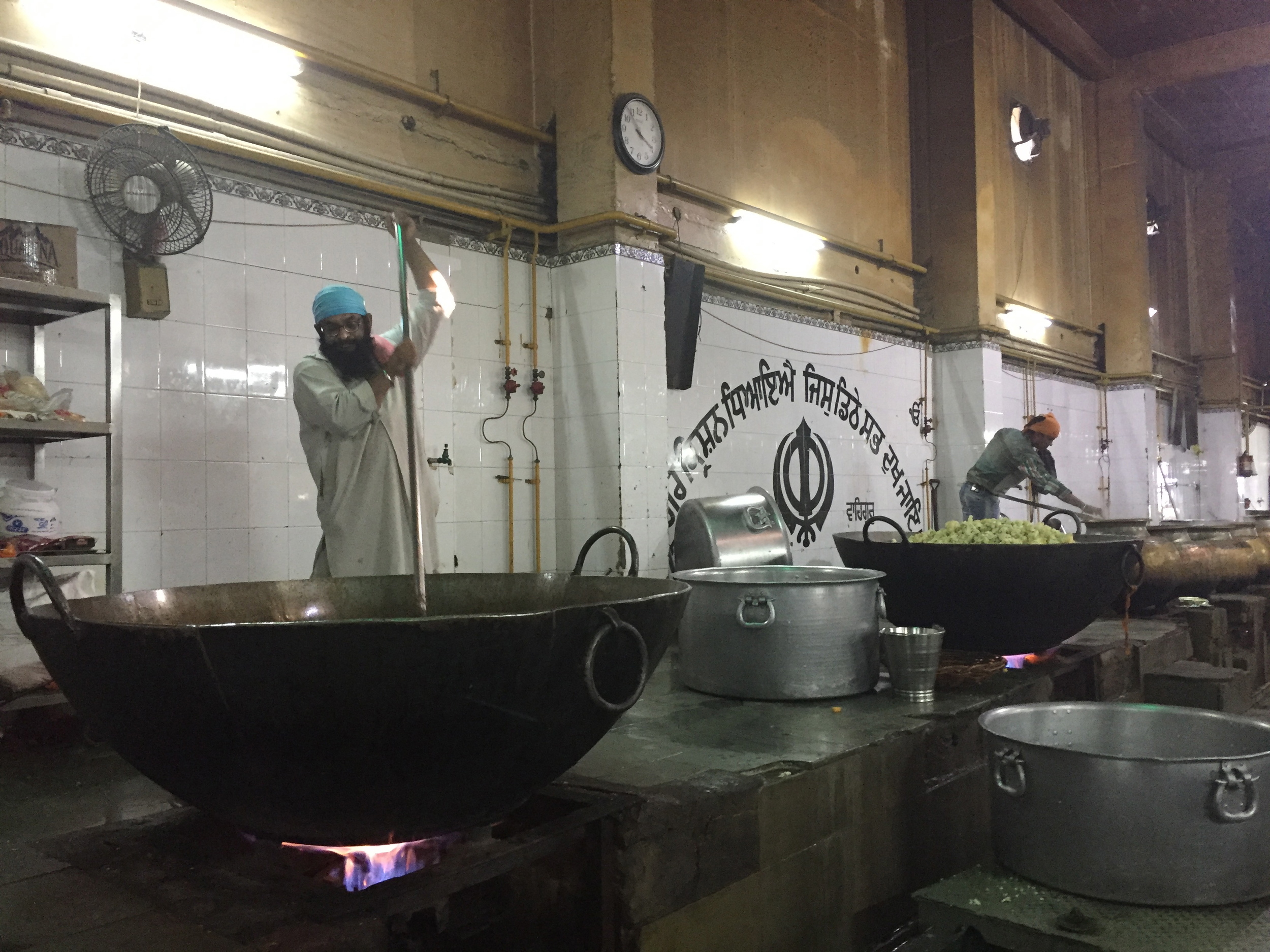 Sikh kitchen staff stir pots of food for the daily meal at Gurudwara Bangla Sahib in Delhi.