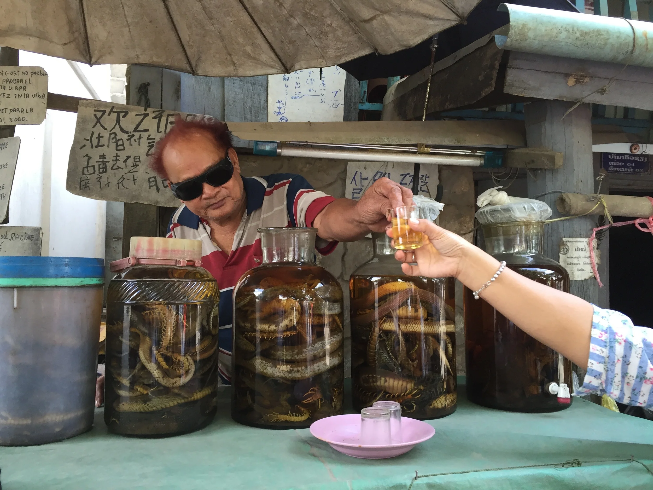 Scorpions, snakes, spiders, and cockroaches are all part of the mix in this locally brewed whiskey...notice the outreached hands seeking to imbibe (not mine!)