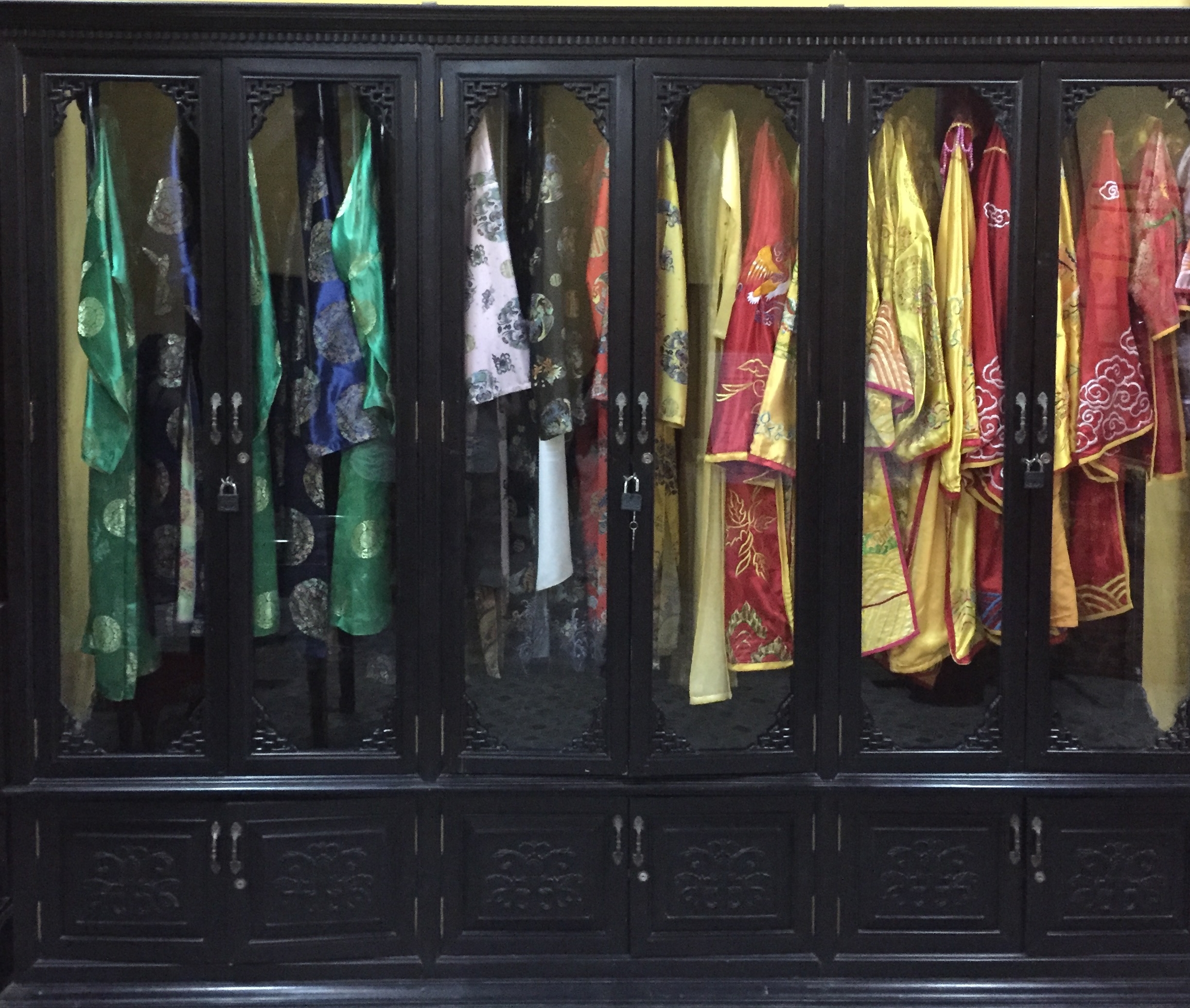 A cabinet full of gold-embroidered silk robes, offering former royal inhabitants of the Imperial City a complete choice of daily wear, arranged by color.
