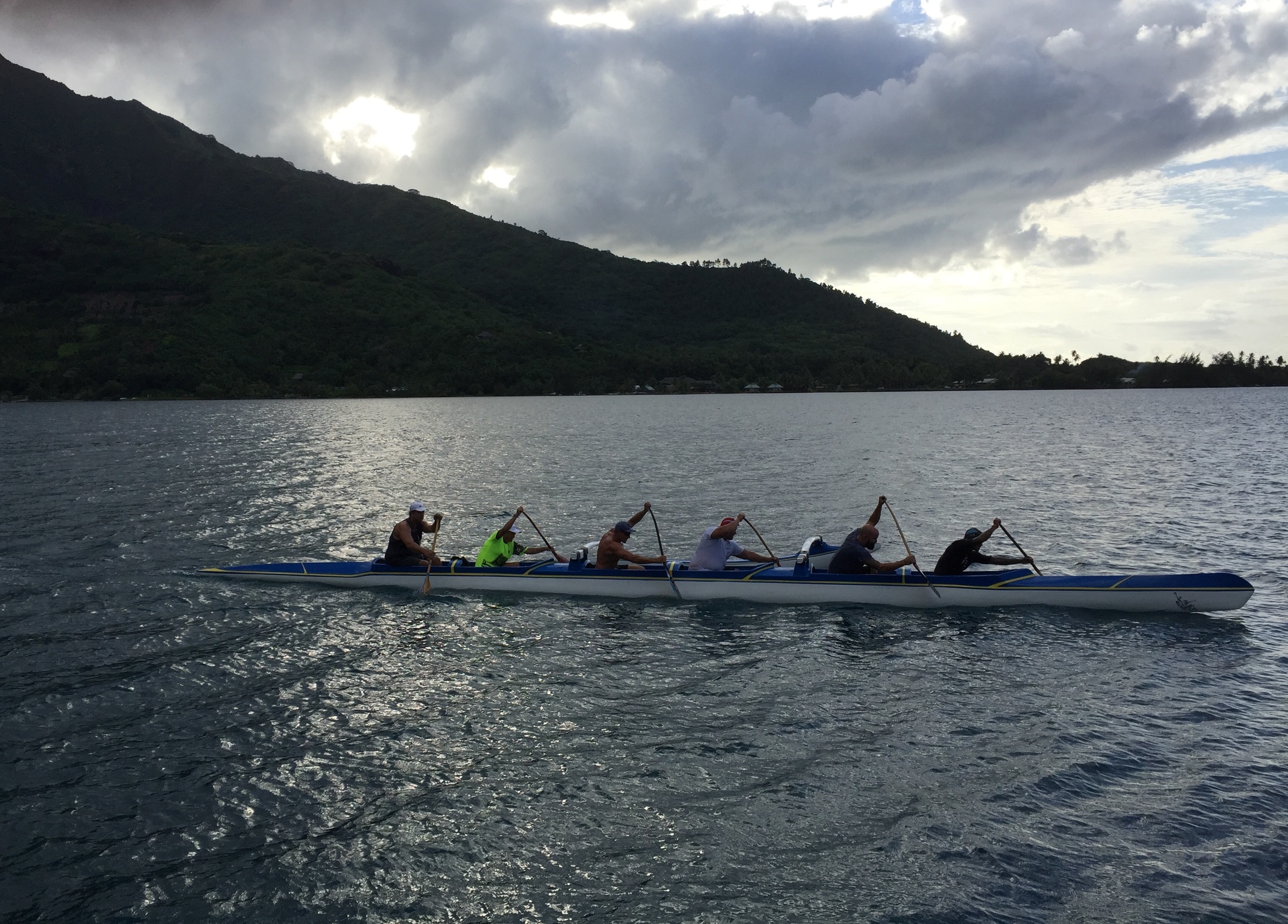 Rowers on Cook's Bay gliding past the Kaveka Hotel just before sunset.