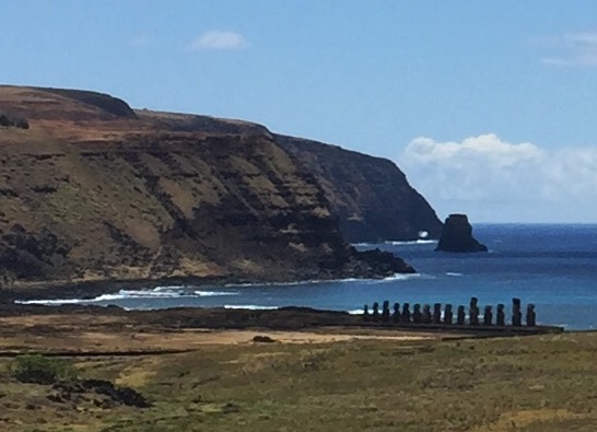 Looking down from the volcanic cliffs of Easter Island to a row of giant Moia along the coast.