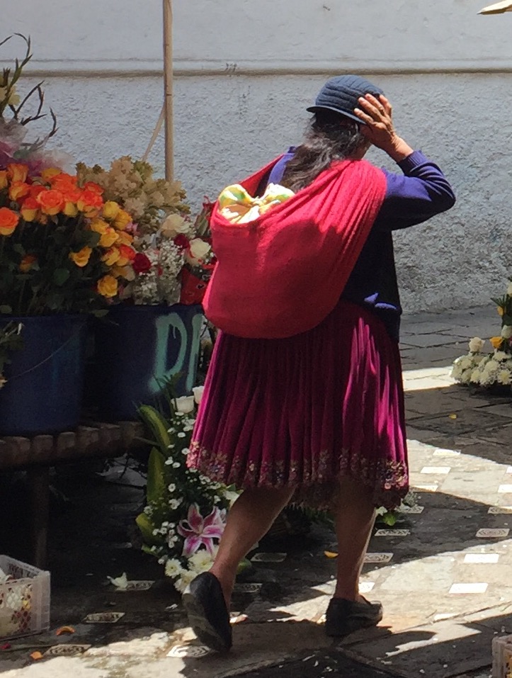 Woman walking through the flower market in Cuenca's downtown.