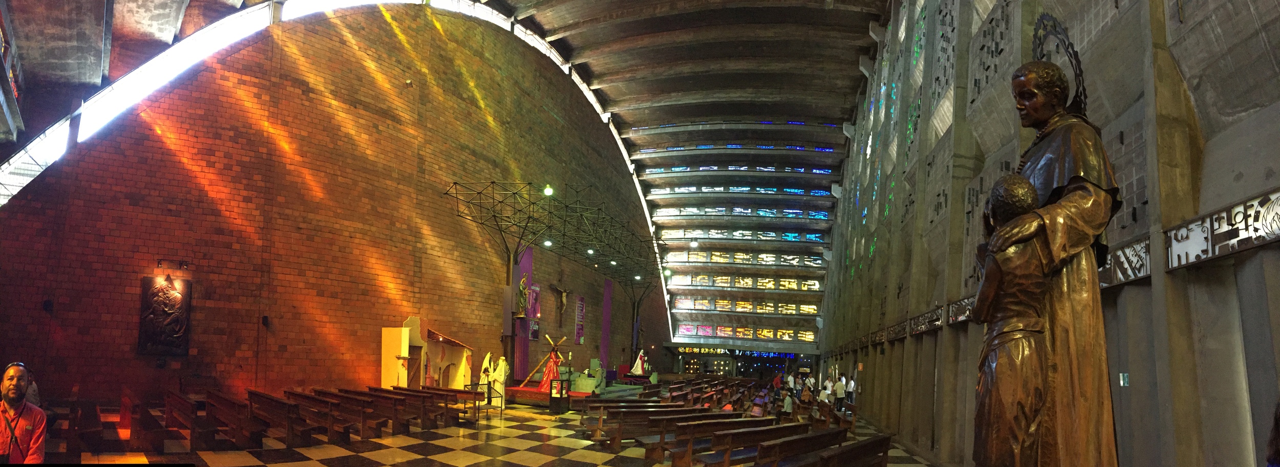 Cascades of natural light through stained glass windows in La Iglesia Rosario create an atmosphere that brilliantly transcends the dull, grey concrete exterior of the building.