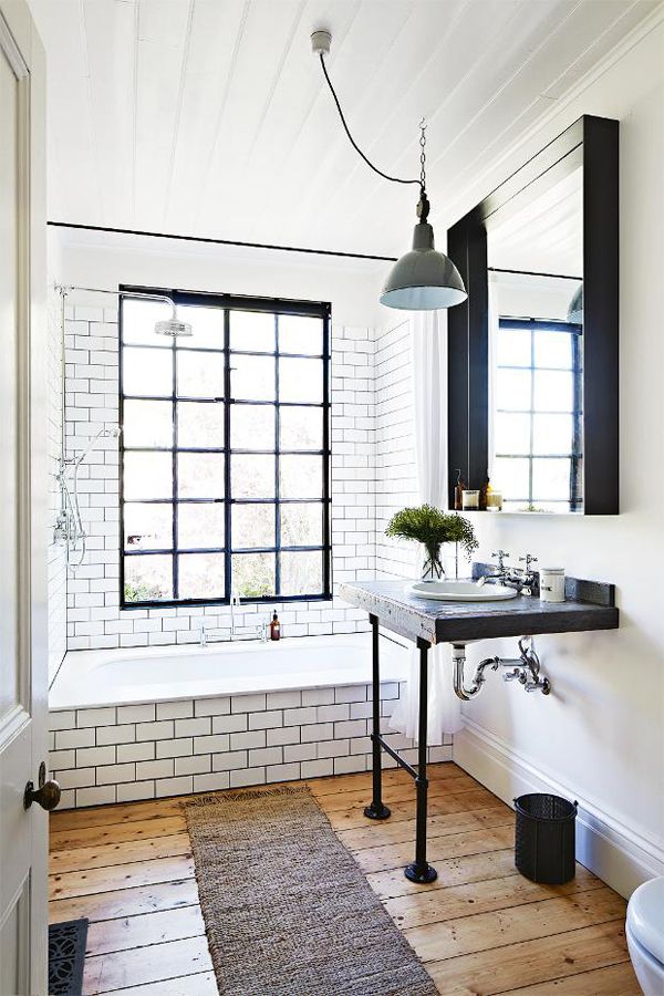 White subway tile + dark grout + rough hewn flooring + black accents 