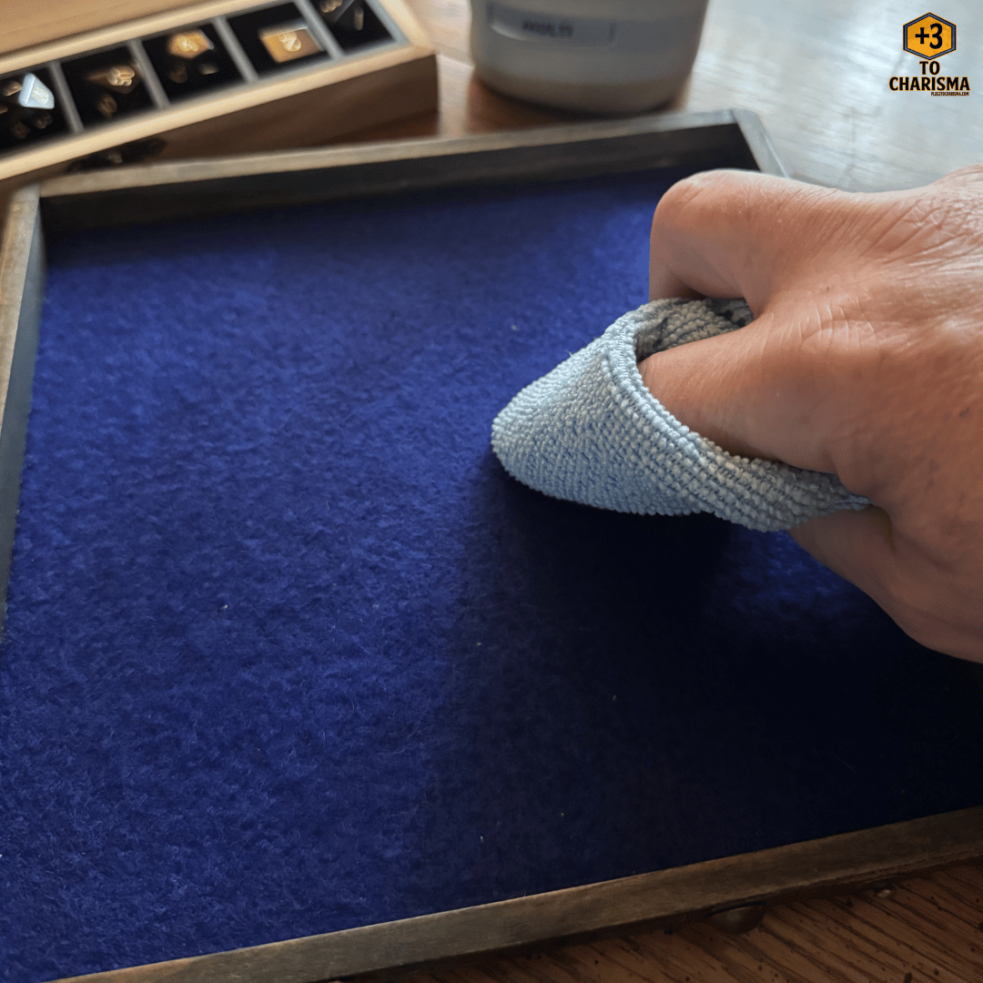 Spot cleaning a felt dice tray with a soft cloth and water - +3 to charisma