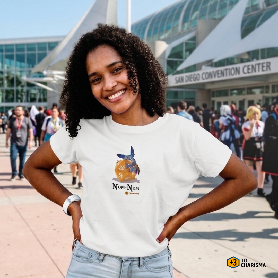 Female model wearing a Nom Nom Goblin Plus 3 to charisma t-shirt in front of a convention center