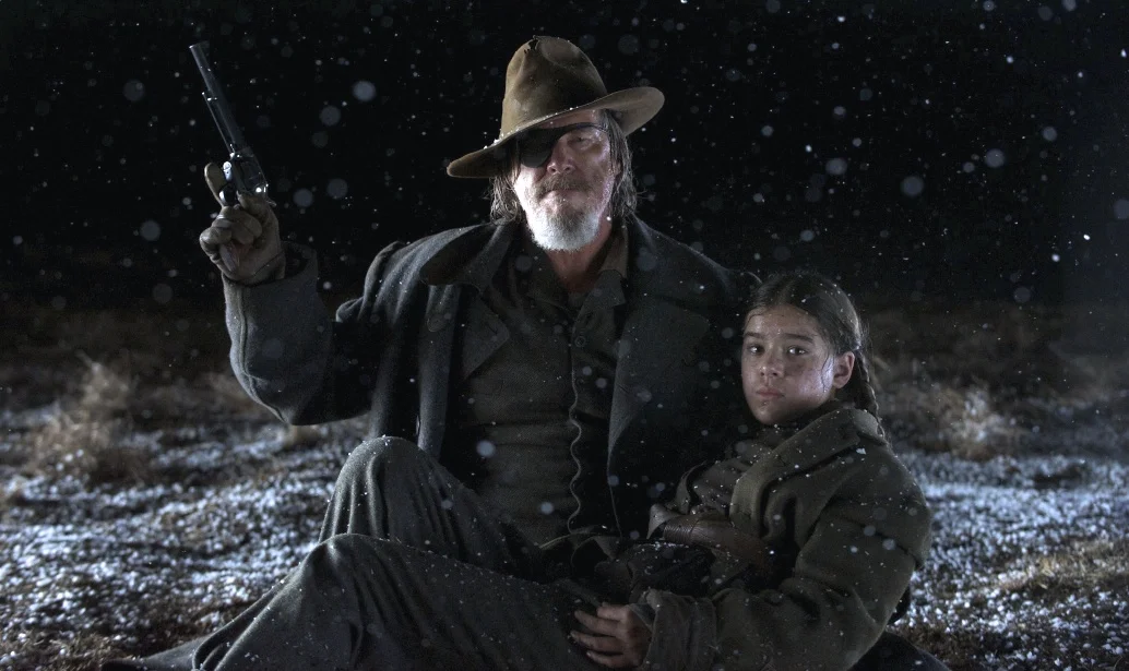Jeff Bridges as Rooster Cogburn and Hailee Steinfeld as Mattie Ross looking forward in True Grit (2010)