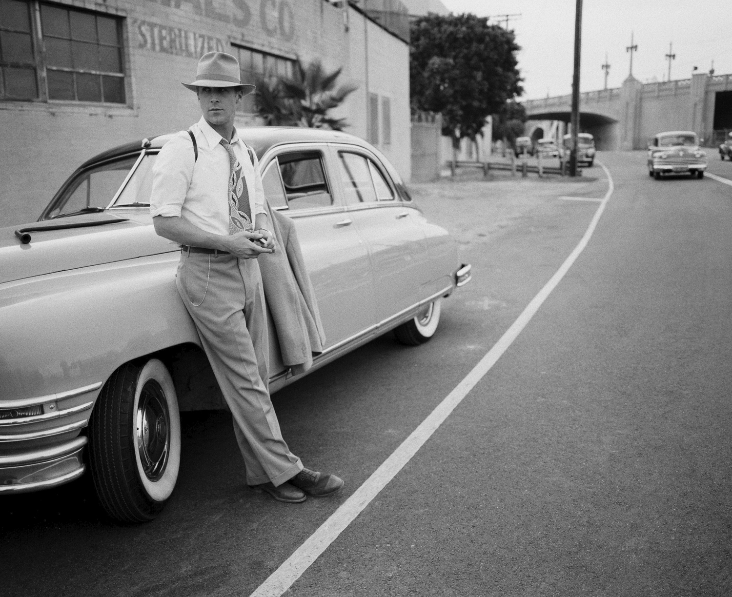 Ryan Gosling as Sgt. Jerry Wooters leans against his girlfriends car in Gangster Squad (2013)