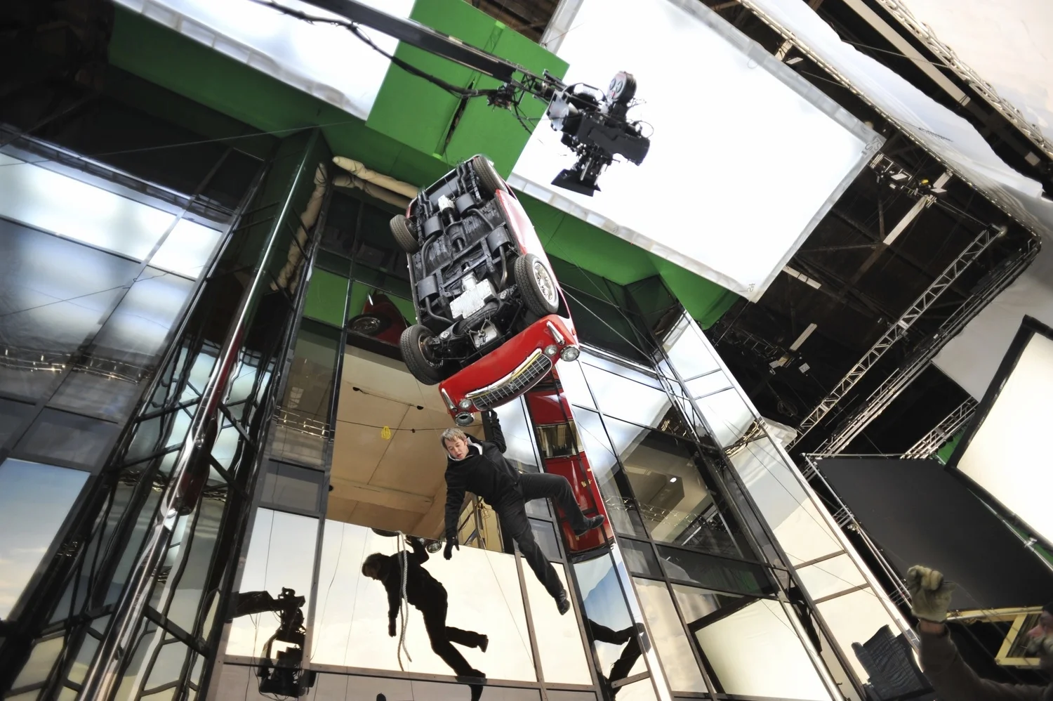 Matthew Broderick as Mr. Fitzhugh dangles from a car while wondering how he got into this mess in Tower Heist (2011)