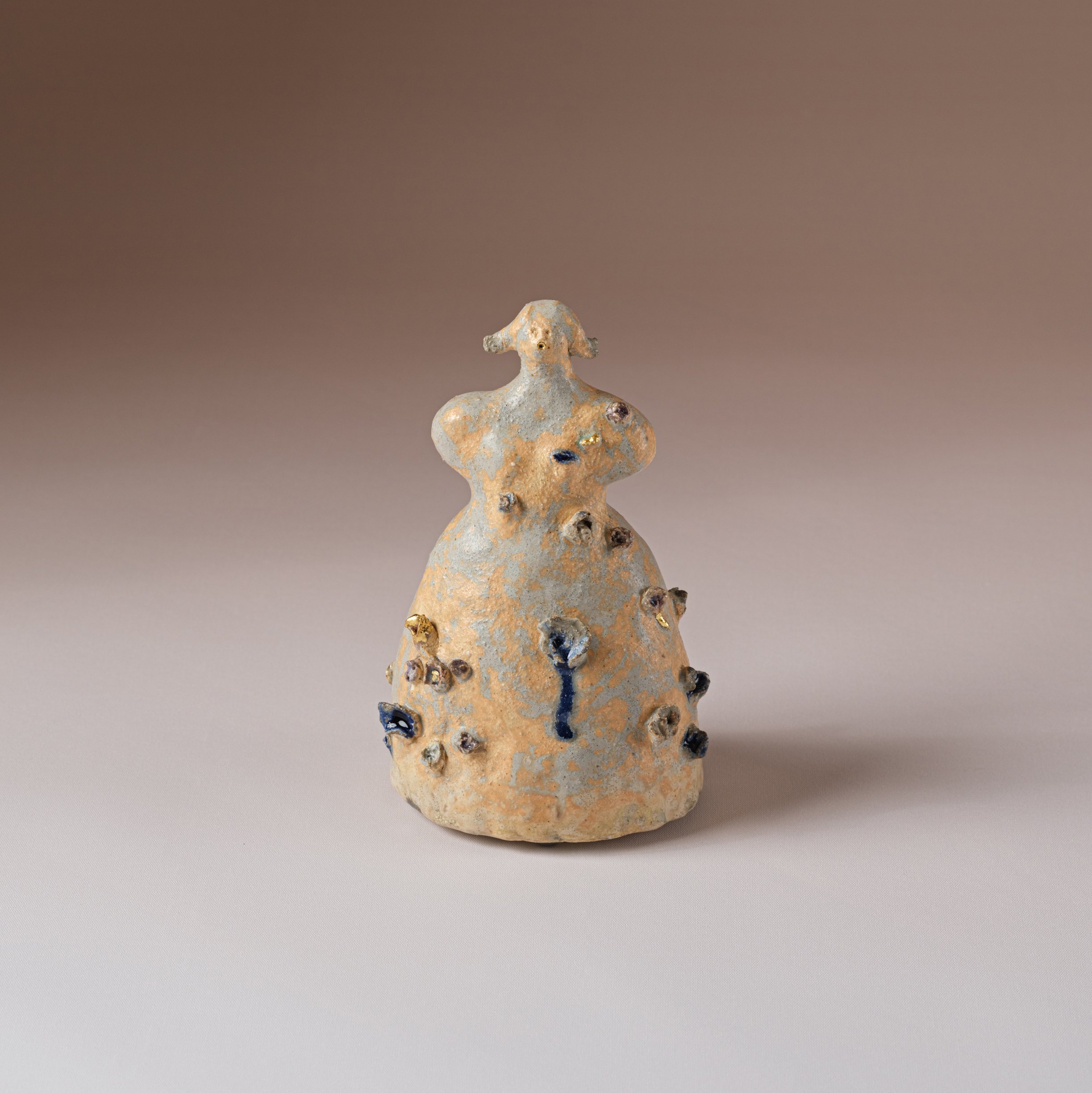 Born of earth and flame, Lady Indigo stands as both healer and enigma. Sculpted in clay and veiled in a luminous glaze, her form embodies the quiet power of transformation. A daughter of Madam Weeds, she is the guardian of ancient herbal remedies, g