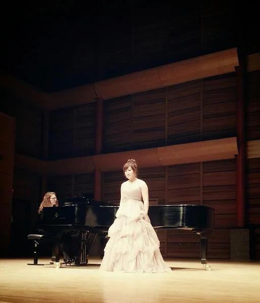 Julie Joohee Jeon is a young passionate composer, singer-songwriter, musician and conductor. Julie was born in South Korea, then she moved to Vancouver, Canada at the age of 13. She studied classical voice in Capilano University and University of Calgary. She achieved a certificate of conducting from Capilano University, and Bachelor of Music in integrated studies with studying voice performance and music education in University of Calgary. Julie conducted school bands, and her own church ensemble and choir. Her own composition works for special occasion services were performed under her directing. She was an assistant music director and actress in a musical association called “Hessed”. Julie is a versatile composer who has an ability to write and perform in different musical genres from classical orchestral to Jazz and Pop. Currently, she is studying film scoring at New York University.