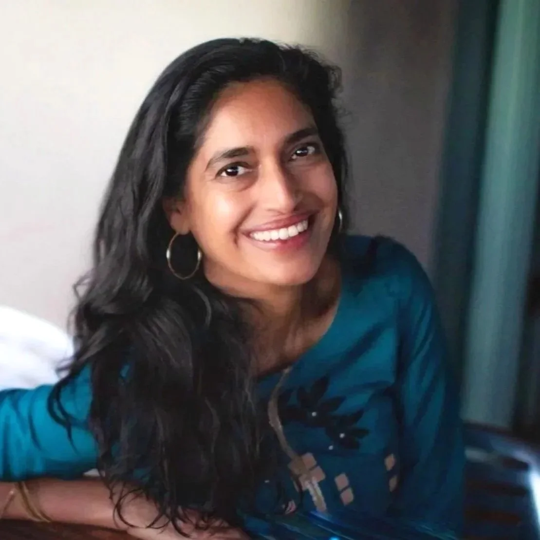 Reema Datta smiling warmly while wearing a teal blouse, creating a welcoming and approachable atmosphere.
