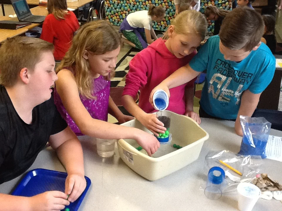 Students from East Side Elementary School in Edinburgh perform a hands-on science experiment in their classroom.