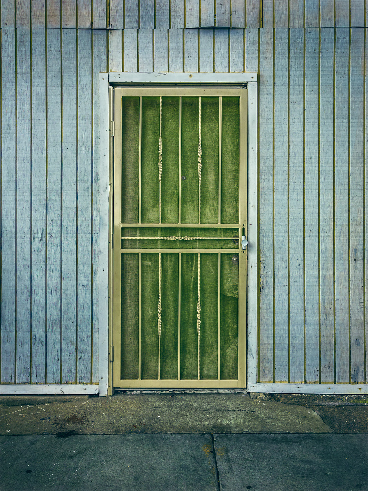 |#8| Moss Green A sickly gate encloses the dusty frame. The warped and buckled siding puckers away from the surface. Mismatched paint in the grout lines suggests a quick and dirty cover-up.