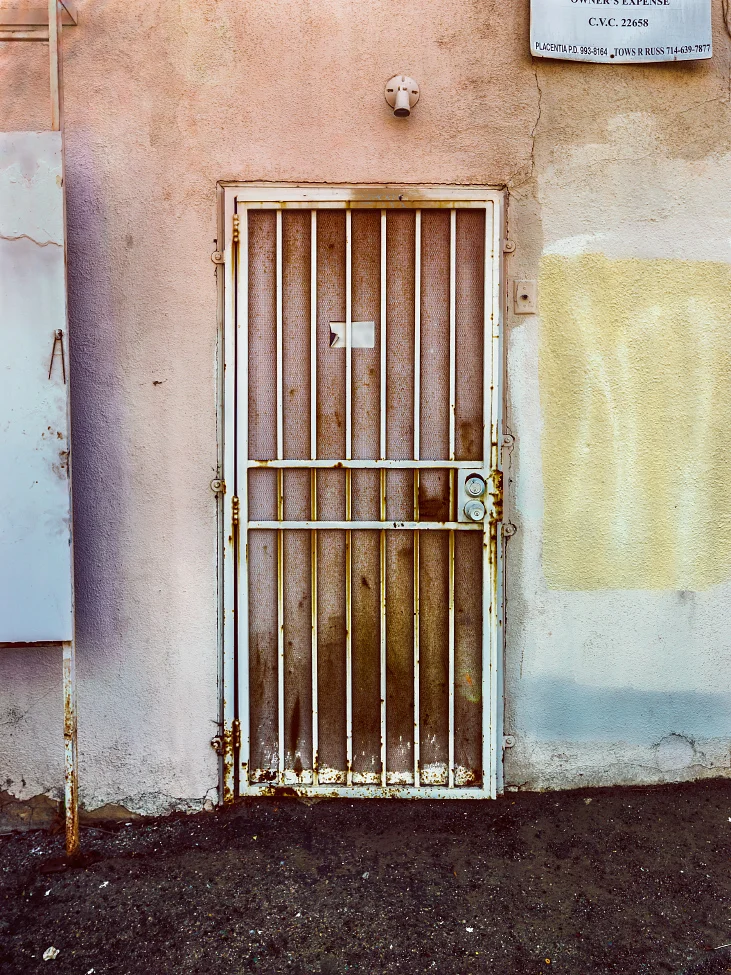 |#23| Mountbatten Pink Beaten and bruised gate, severely rusted. Coarse, crumbling asphalt breaks down from the hot sun. A truly nasty Neapolitan.