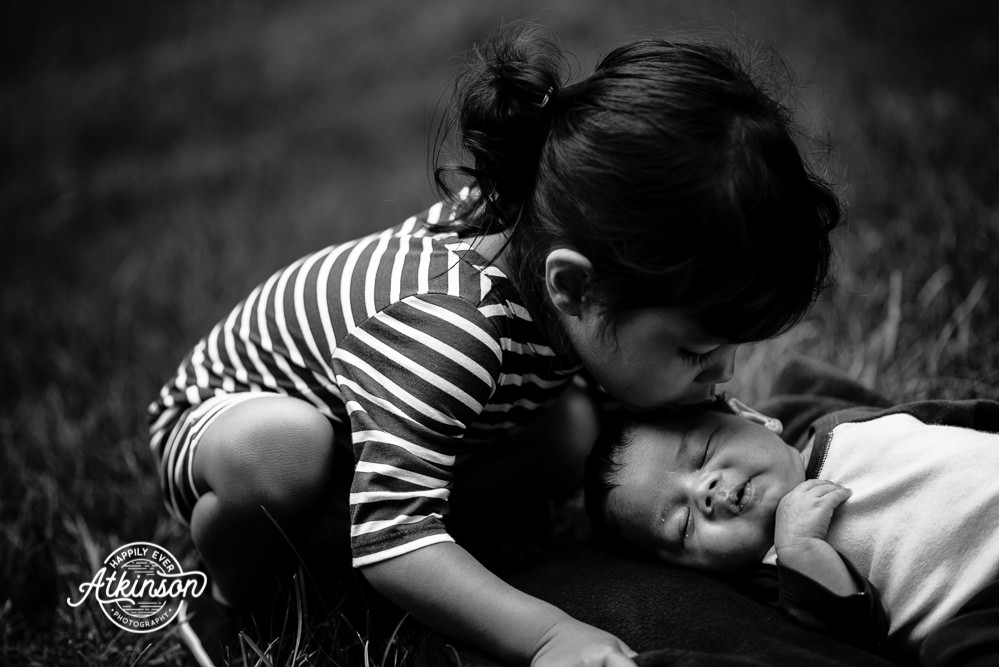 big sister kisses newborn brother