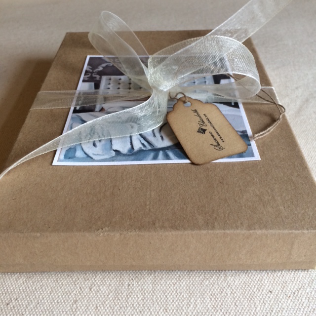 Gift box of 8 fold note cards on kraft paper, wrapped with a fancy ribbon and coffee-stained tag.