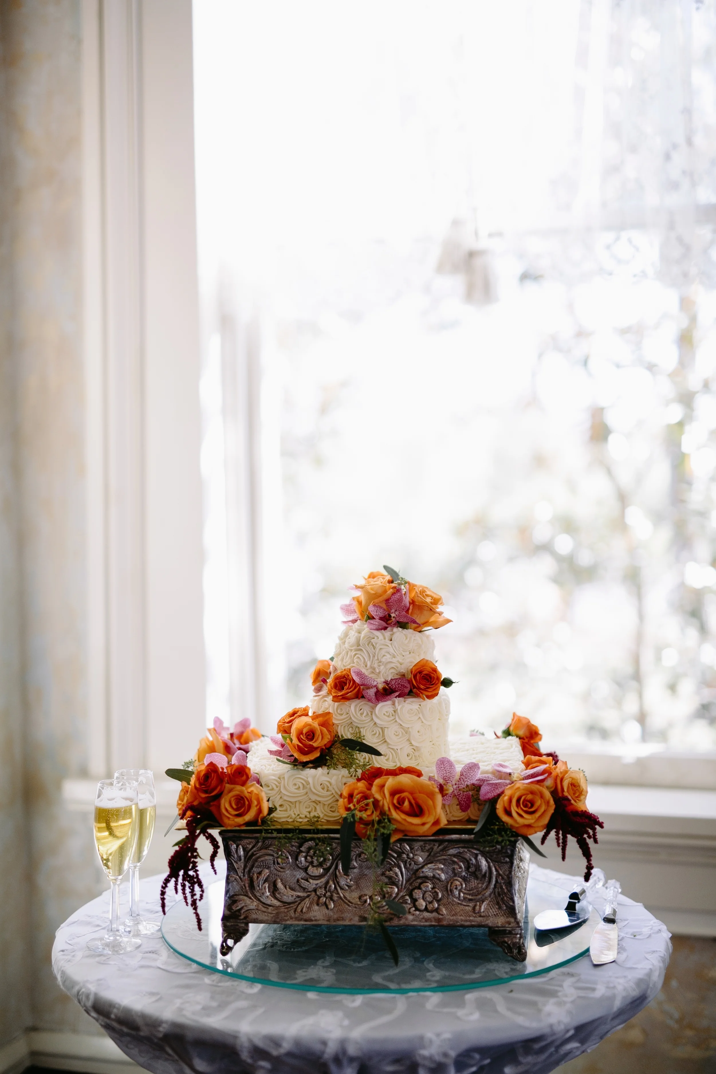 Add seasonal vibrant florals around each cake tier to add pops of color. The popular rosette texture creates both dimension and an elegant romantic look. Photo: Q Avenue Photo