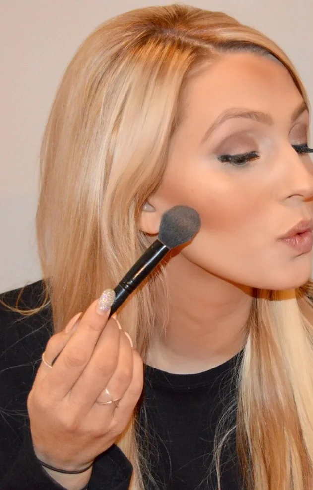 making a kissing face, I apply my bronzer by Mac in 'give me sun' in the hollow of my cheek.