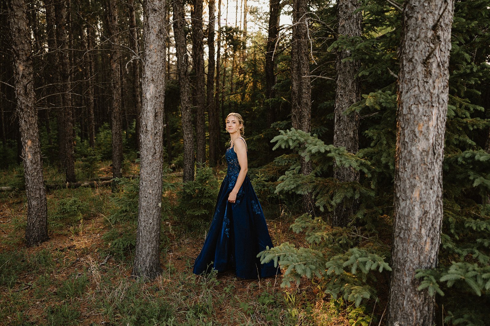 Grad portrait in Birds Hill Park forest near Winnipeg with natural light and a formal dress