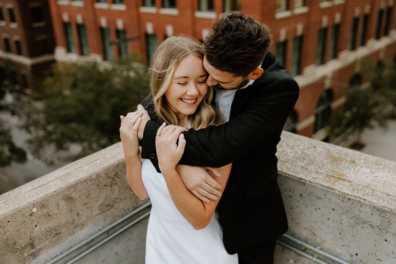  Couple embracing on a rooftop in the Exchange District during an engagement session in Winnipeg 
