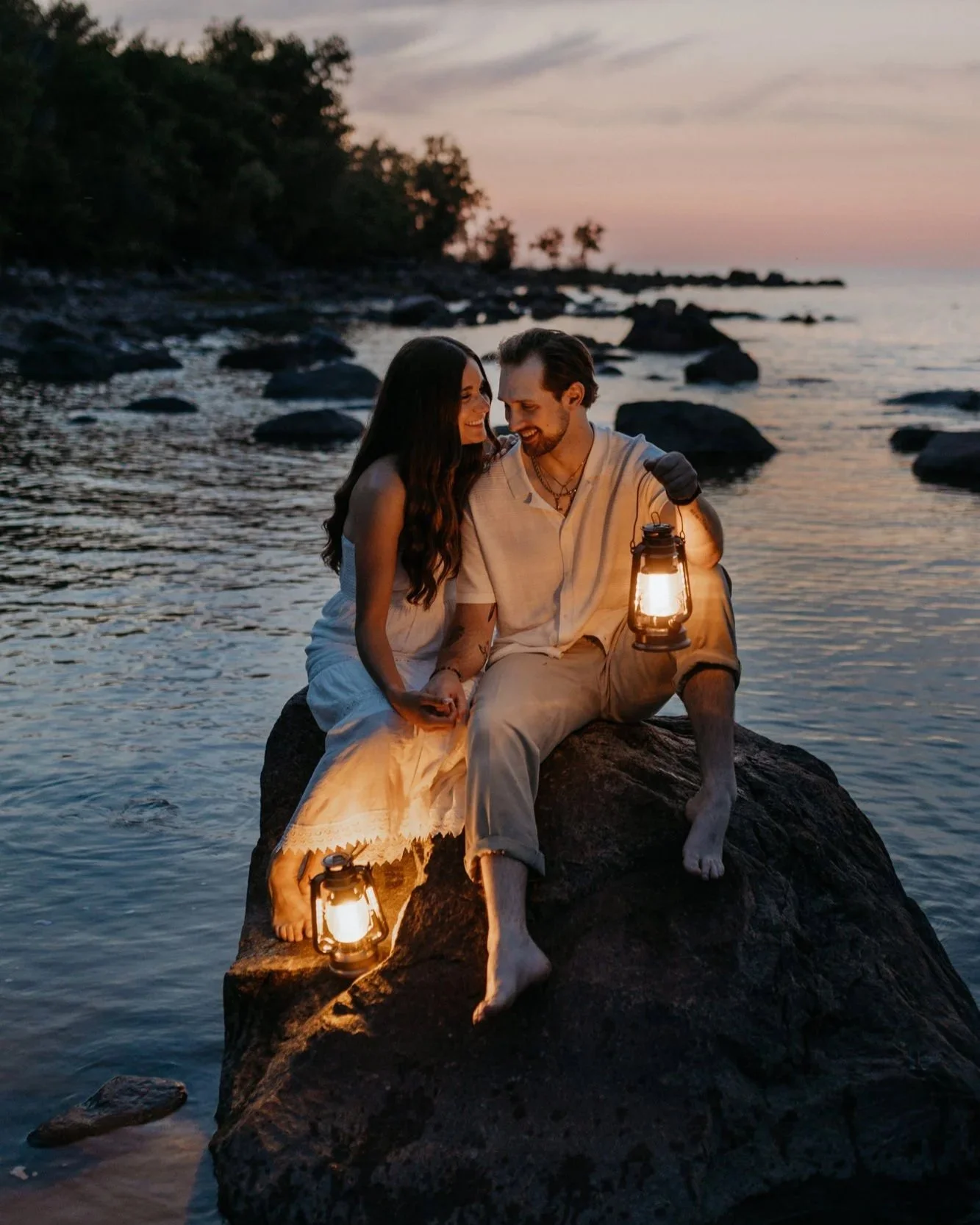Couples sitting on a rock at Grand Beach Manitoba Holding Lanterns