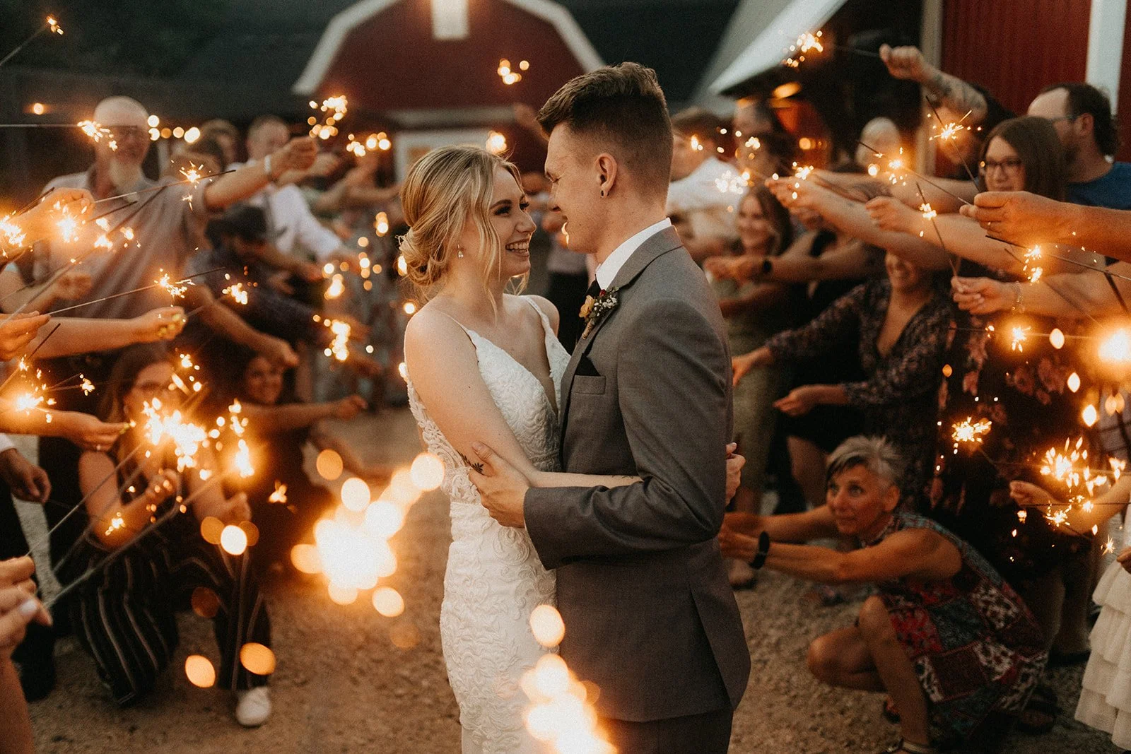 Couple surrounded by sparklers during a wedding exit at the Rustic Wedding Barn near Steinbach, Manitoba