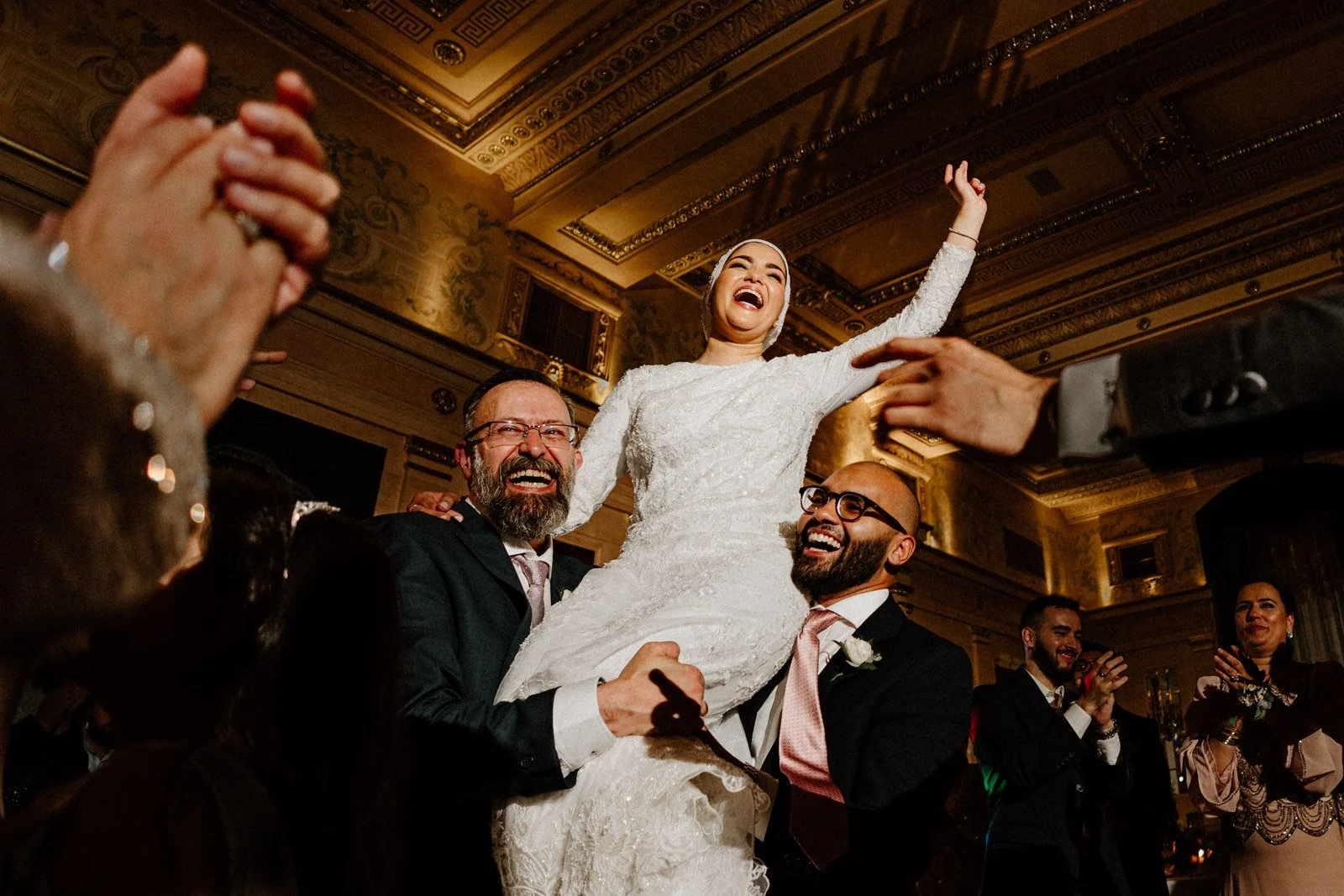 Bride being lifted by guests on the dance floor at a Fort Garry Hotel wedding in Winnipeg