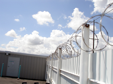 Solid Steel Fencing and Razor Wire.JPG