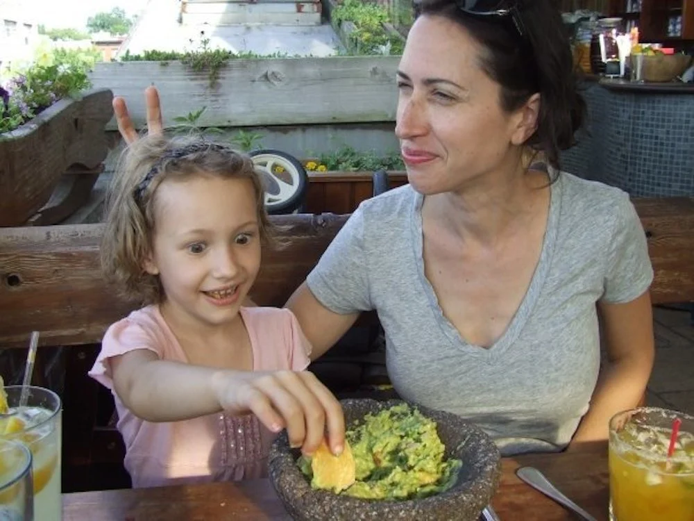 My daughter and me, c. 2009; guacamole for her, margarita for me.